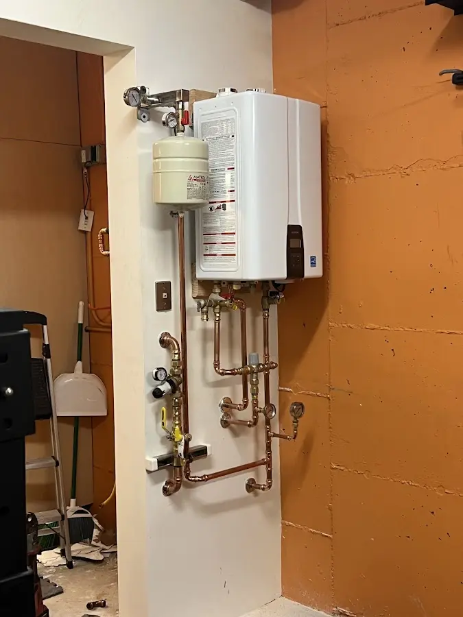 Plumbing technician inspecting water heater connections in Oak Ridge